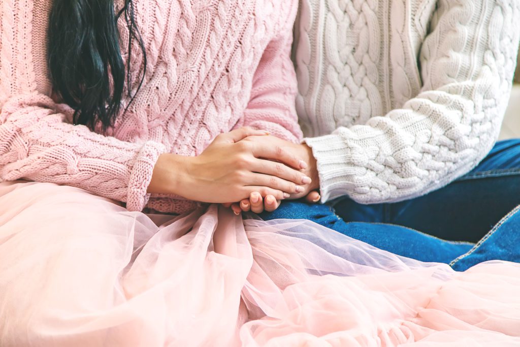 Dos personas cogidas de la mano en señal de apoyo