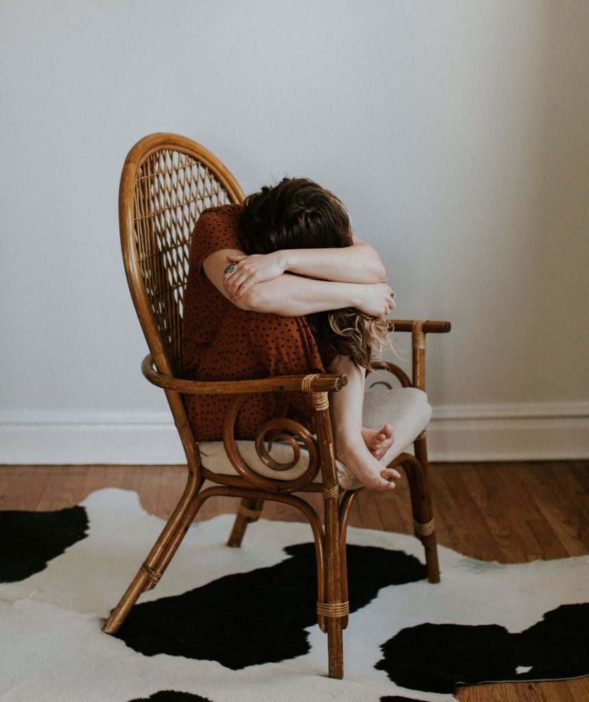 Mujer sentada en un sillón de mimbre